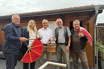 Mehrere Personen stehen vor einer Sauna